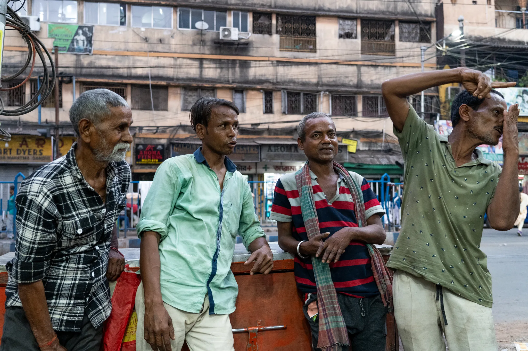 Men pausing on the market street, India