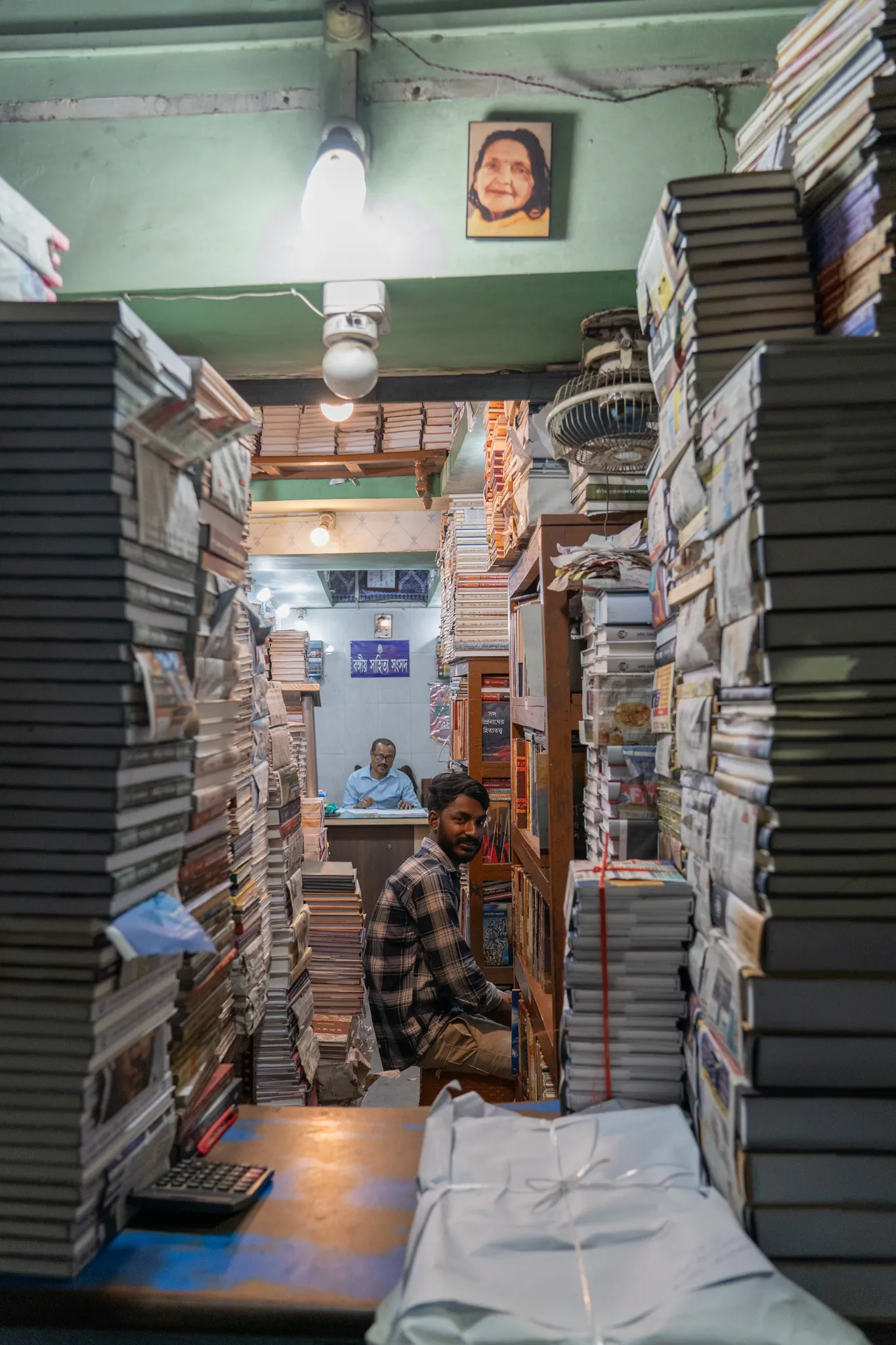 Bookseller among his stacks, India