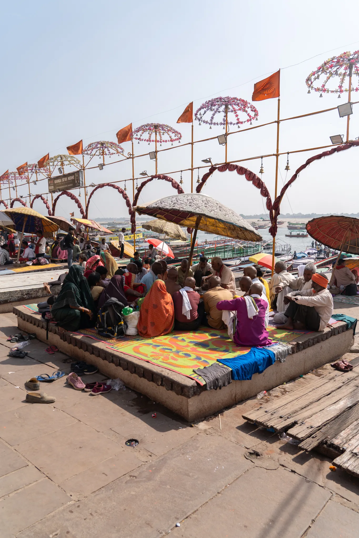 Pilgrims gathered beneath umbrellas on the ghats in Varanasi, India