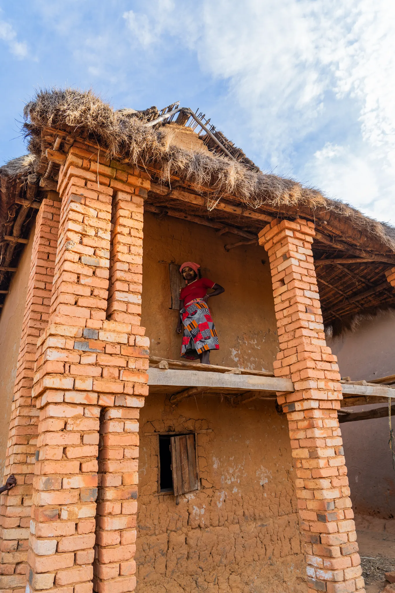 Woman on the balcony of a brick house
