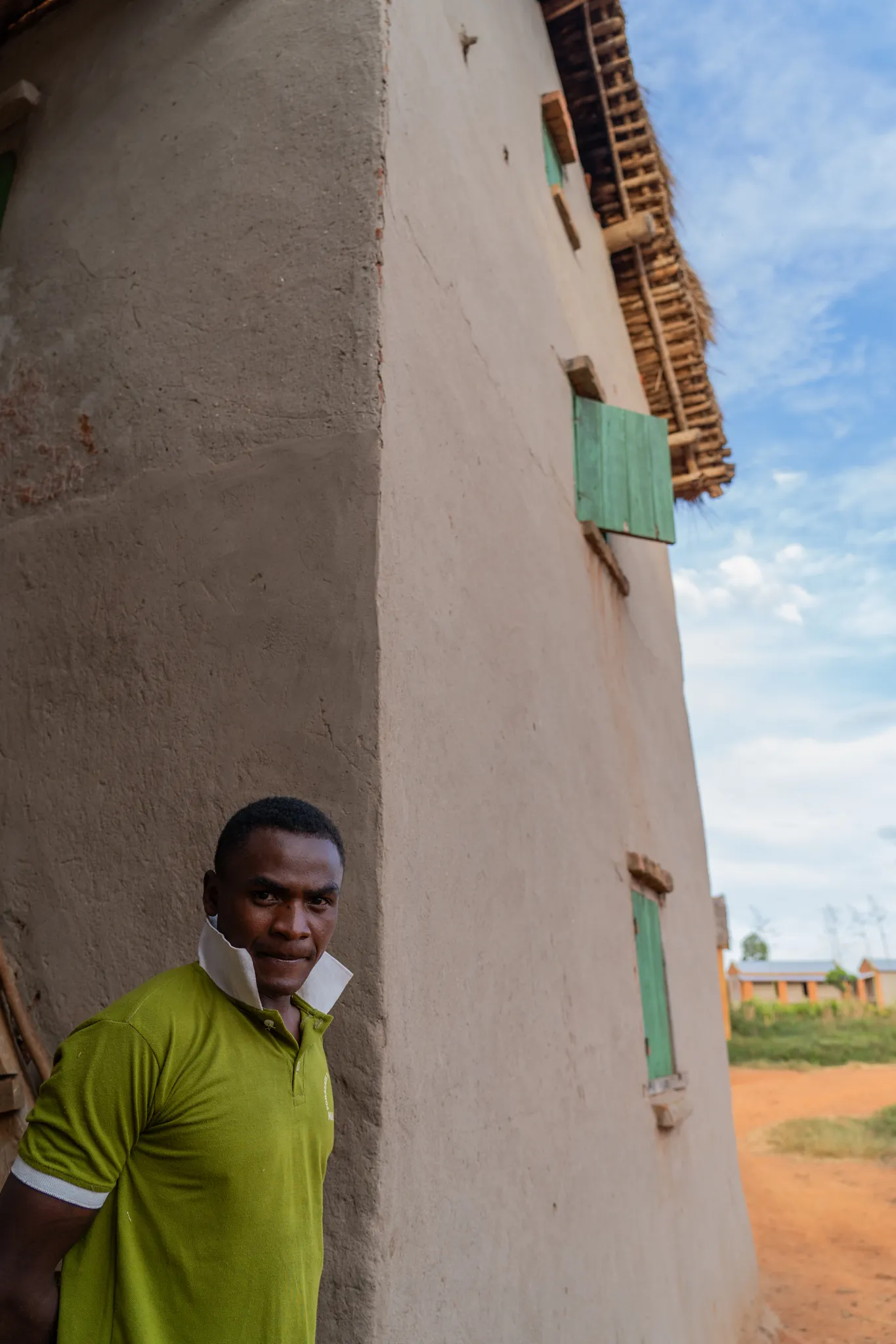Portrait of a man beside a mud-brick wall