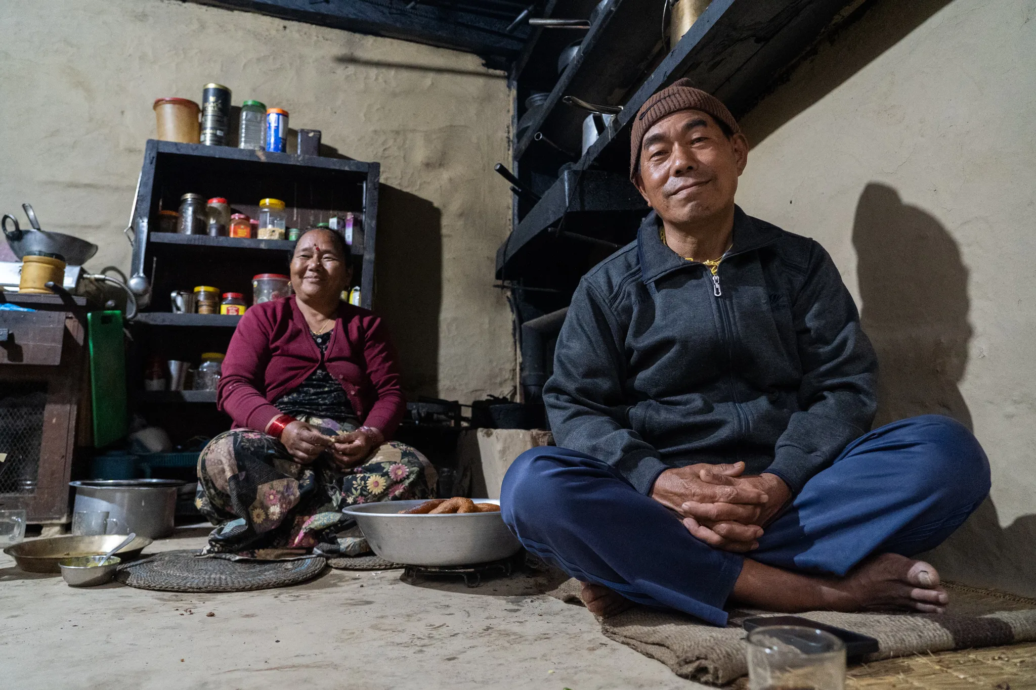 Portrait of a couple by their kitchen shelves