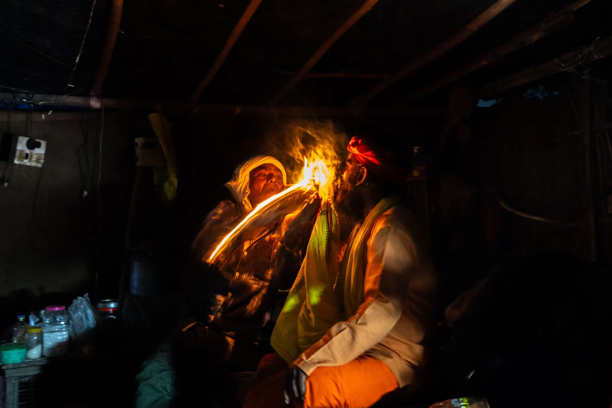 Sahdus smoking chillum before bed, the photo taken as the match is tossed, India