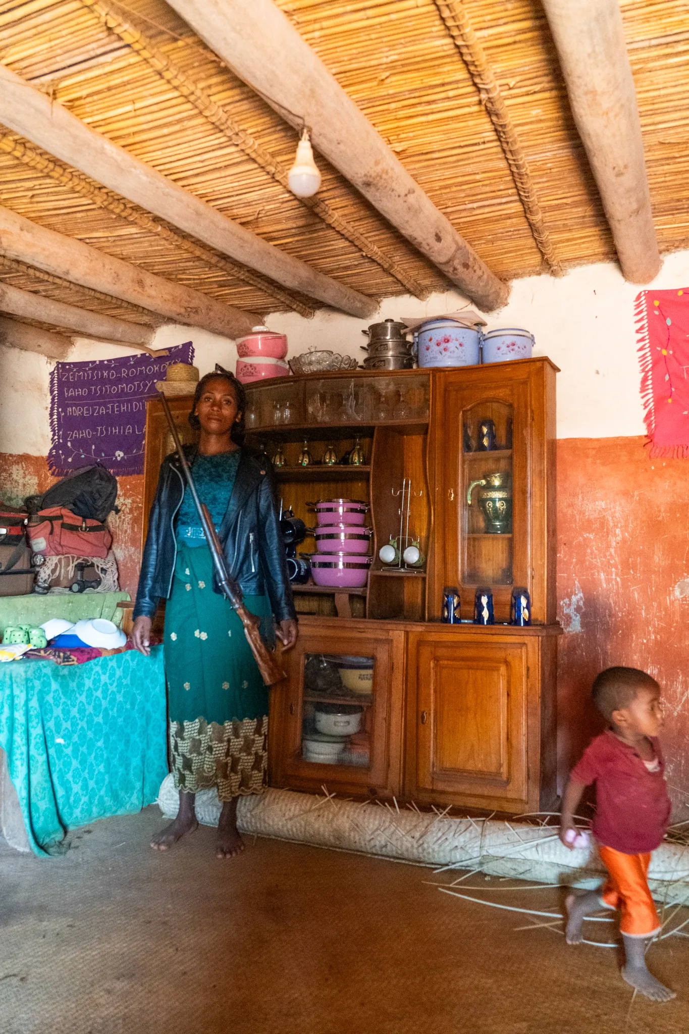 Woman with a rifle inside her home