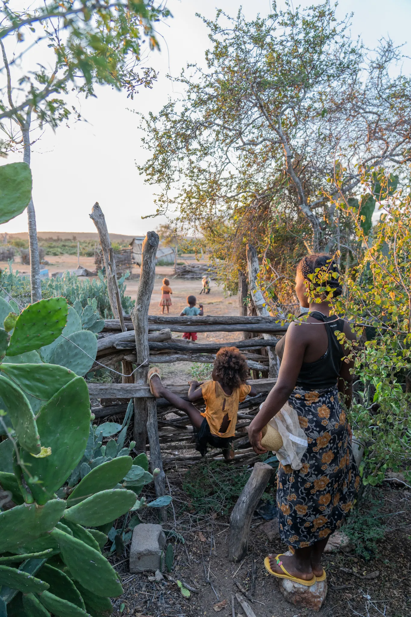 Woman and children at a wooden fence