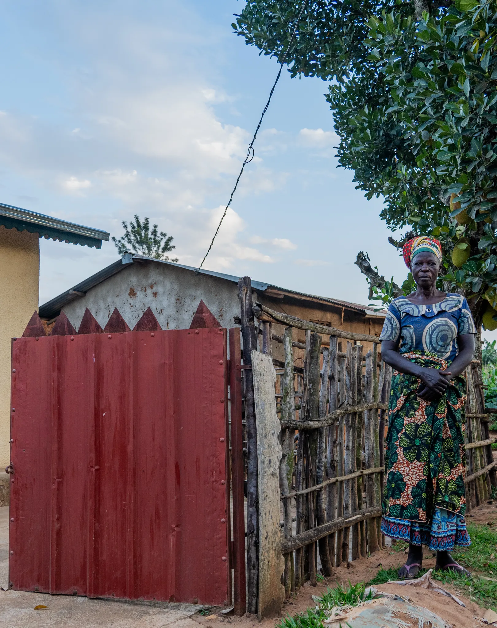Woman by a painted red gate, Rwanda