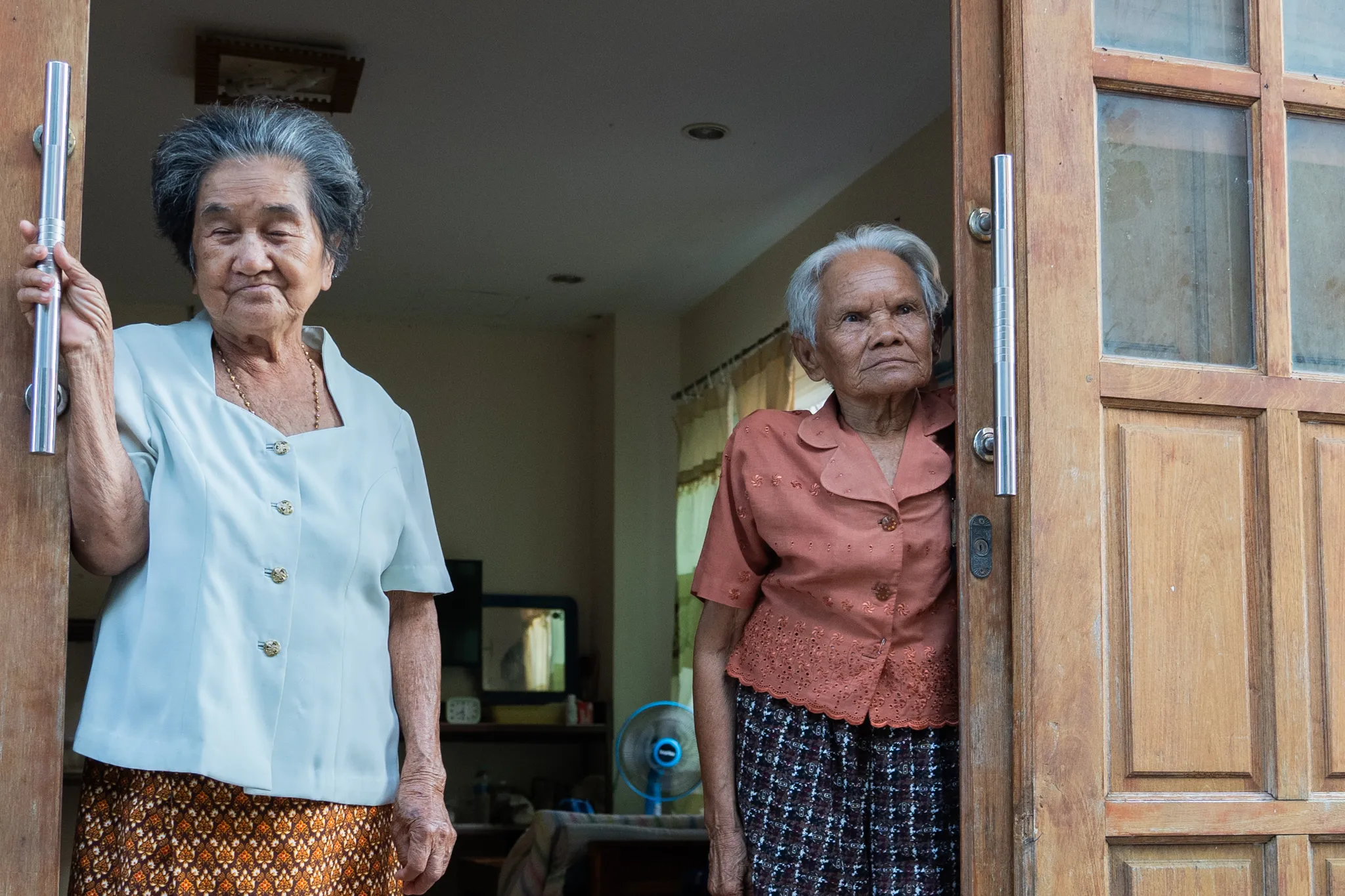Two elderly women standing in a doorway