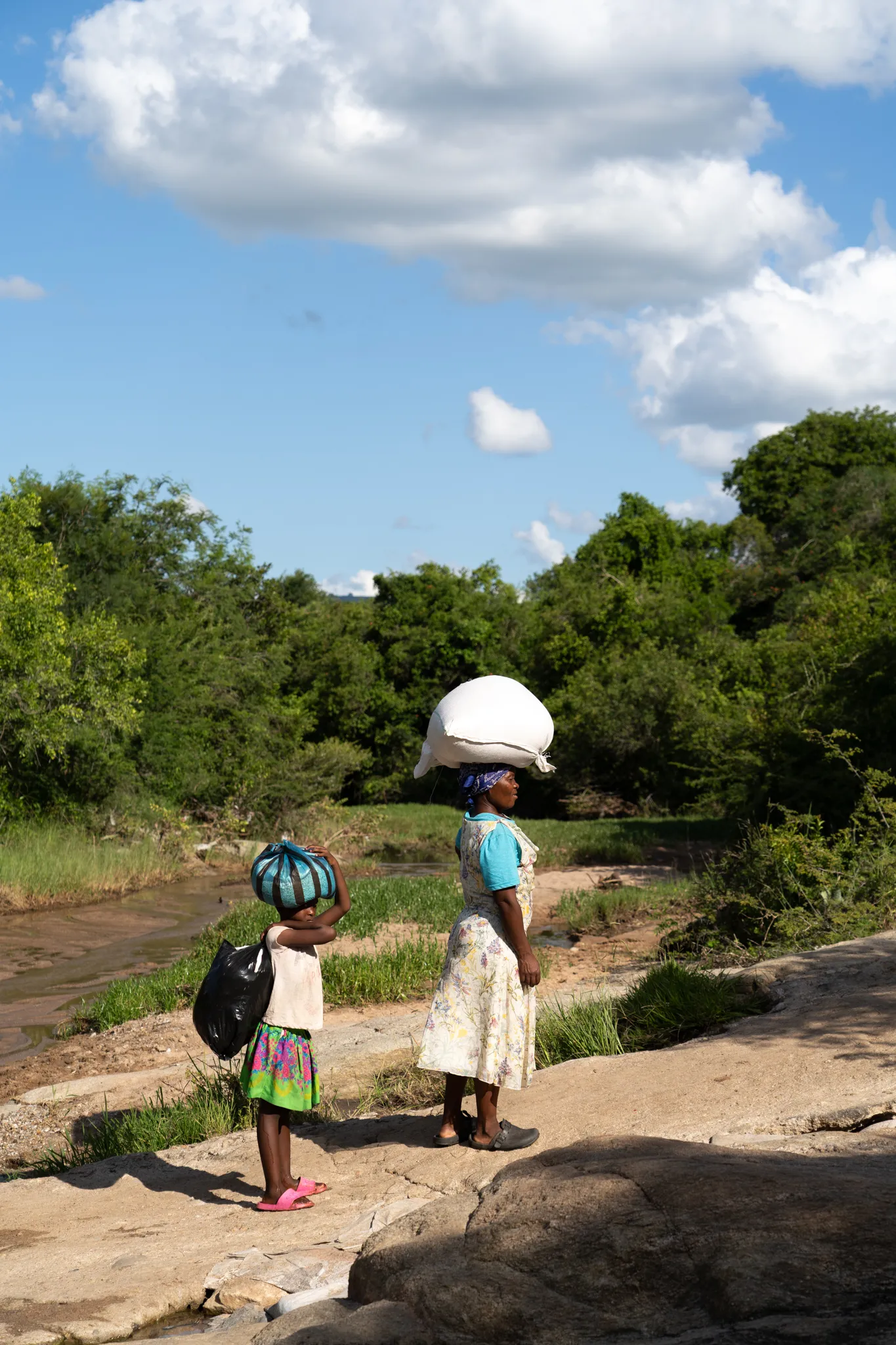Carrying loads home along a rocky path, Eswatini